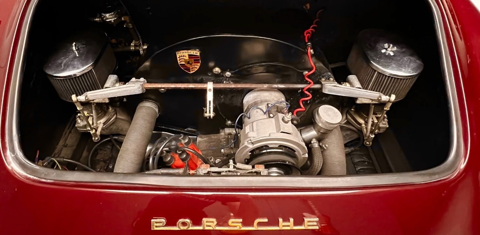 Rear engine bay of a Porsche 356 replica with twin carburetors and a fan shroud